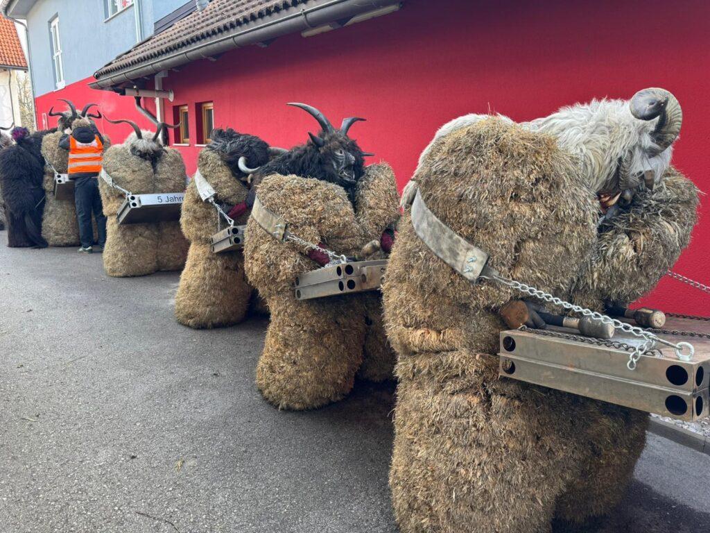 In einem Festivalumzug gekleidete Teilnehmer in traditionellen Kostümen aus Stroh und Tierhäuten